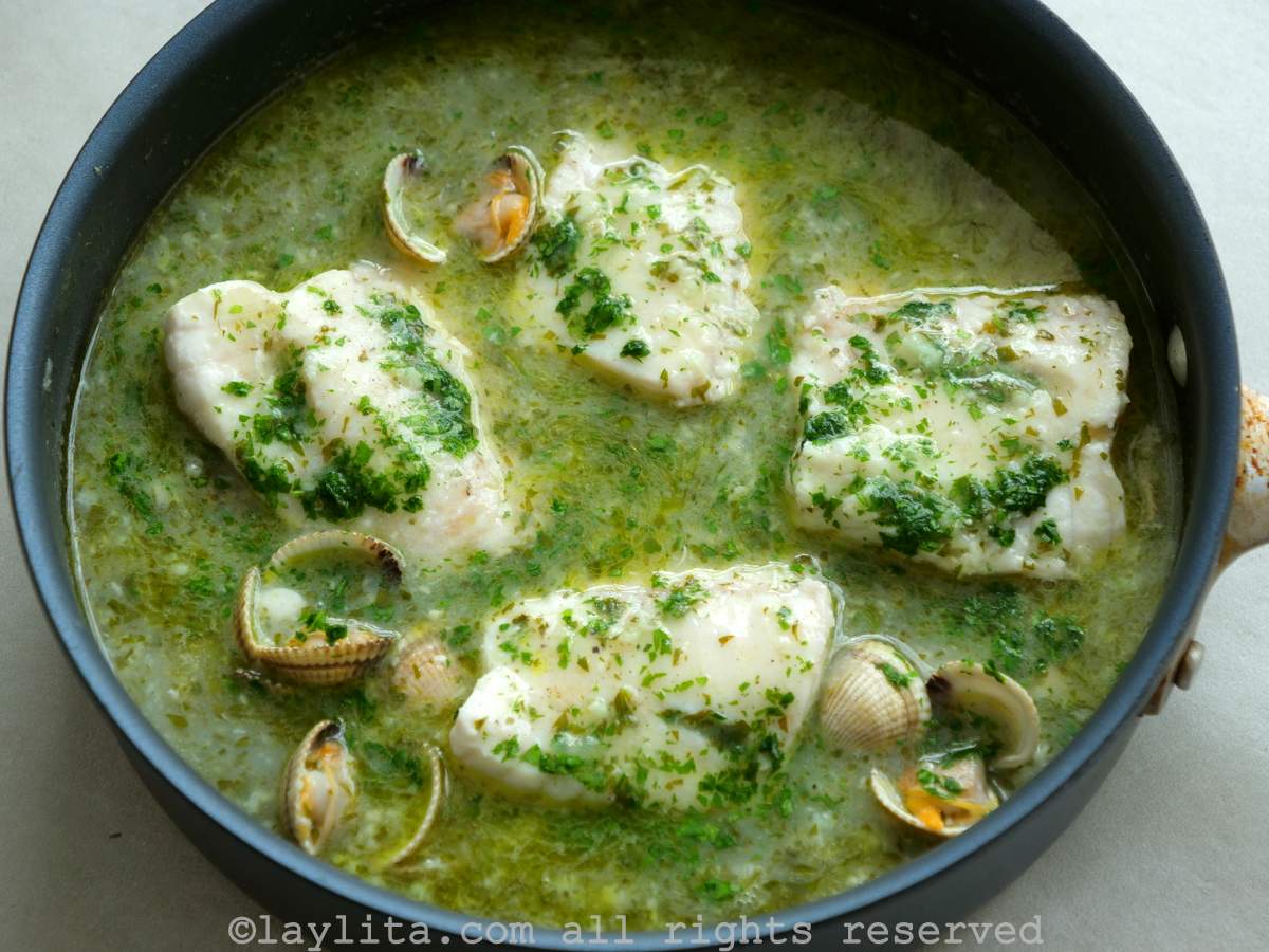 Pescado en salsa verde con almejas servido en una sartén