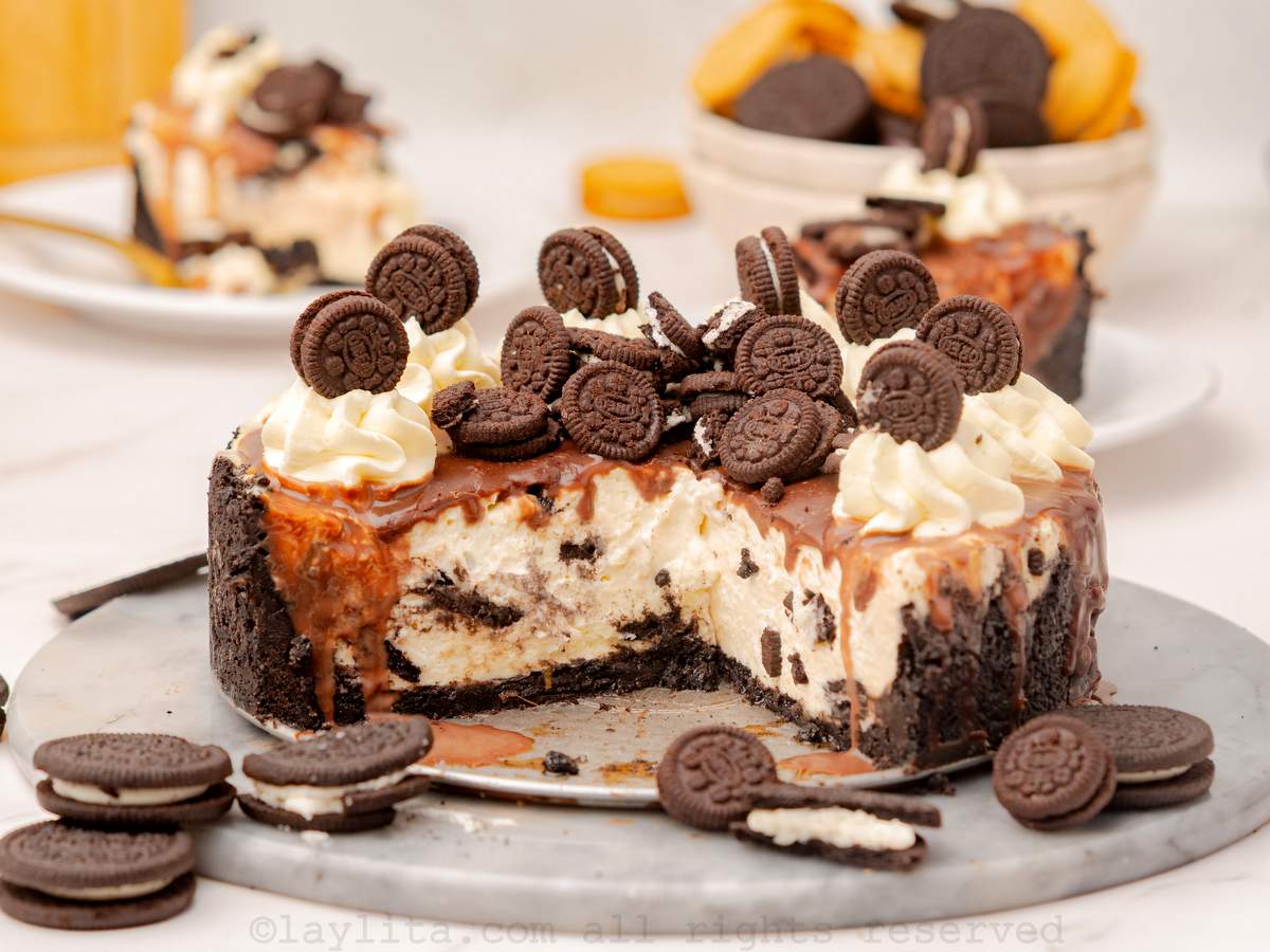Vista lateral de un cheesecake de galletas Oreo con unas rebanadas faltantes para mostar el centro del cheesecake