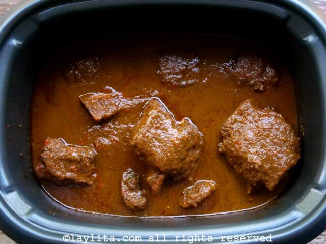 Una olla de cocción lenta llena de costillas de res cocidas en una salsa espesa