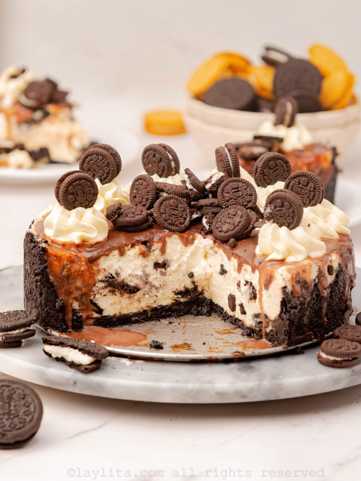 Un cheescake de galletas Oreo en una bandeja con algunas rebanadas faltantes para mostrar el interior.