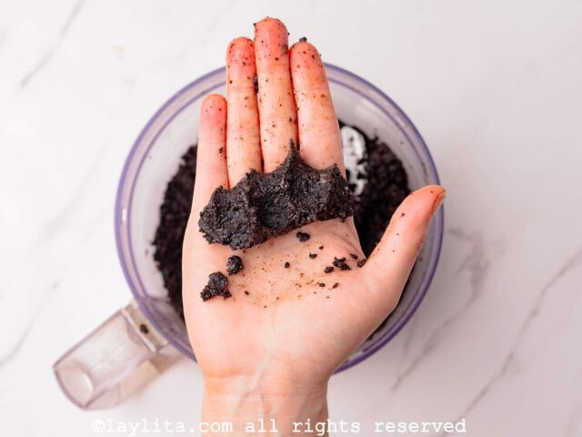 Una mano mostrando la mezcla de galletas de chocolate trituradas