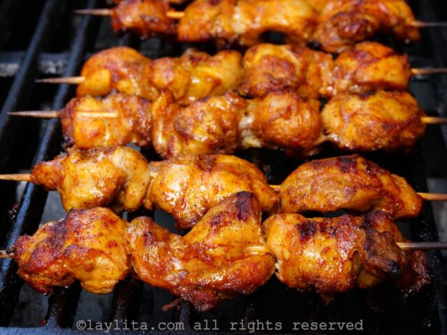 Brochetas de pollo asando en la parrilla