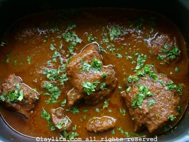 Seco de costilla de res en una olla con salsa y cilantro picado encima