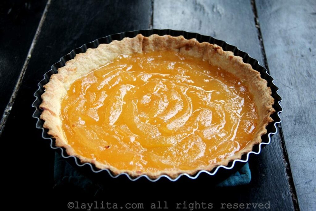 Una tarta de babaco en el molde de hornear encima de una mesa de madera negra