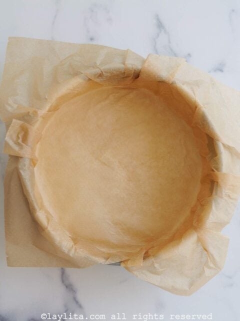Un molde de cheesecake cubierto de papel de hornear