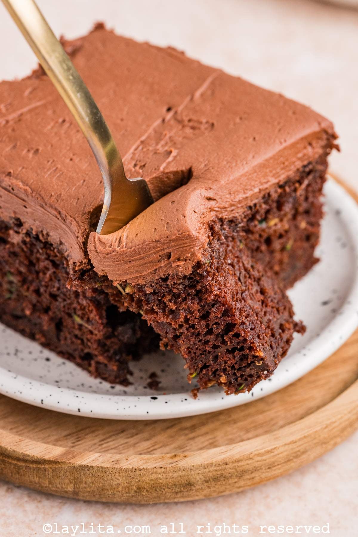 Una rebanada de pastel de chocolate y zucchini con un tenedor mostrando un bocado del pastel