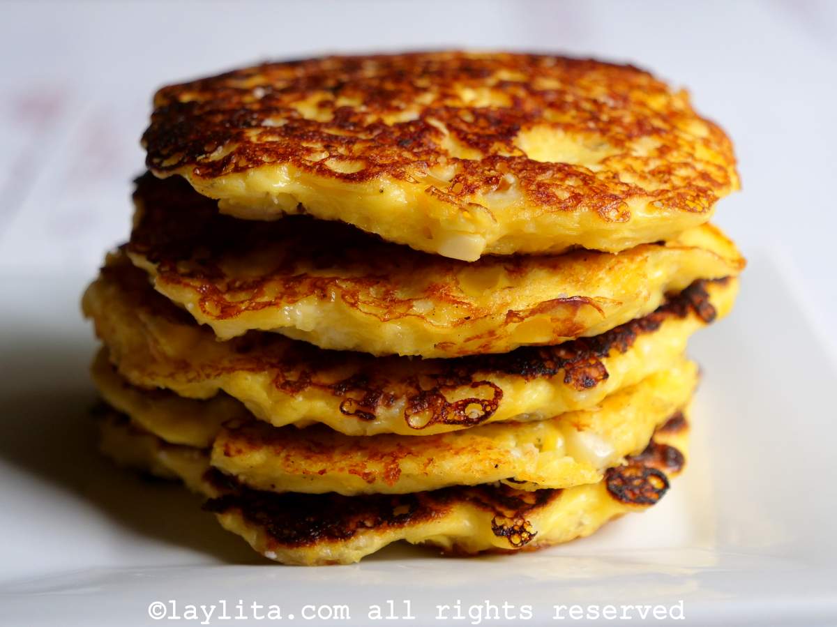 Cinco torrejas de maíz y queso apiladas una sobre otra en un plato blanco