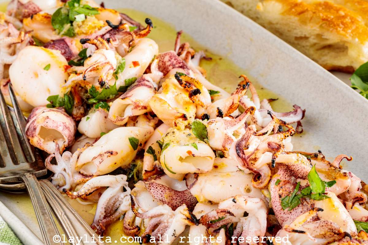 Primer plano de calamares asados con aderezo de limón y perejil