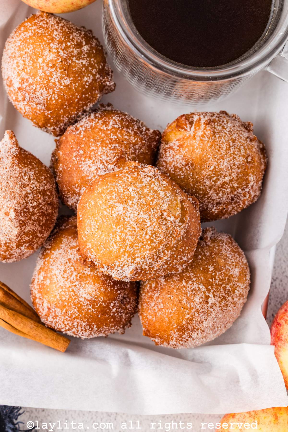 Vista superior de varios buñuelos de manzana al lado de una taza de café