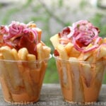 Salchipapas con salsa rosada y curtido de cebolla