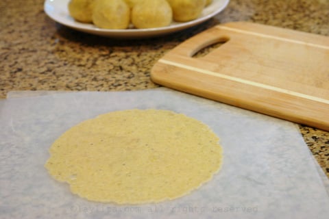 Use a tortilla press or a cutting board to flatten the balls of plantain dough