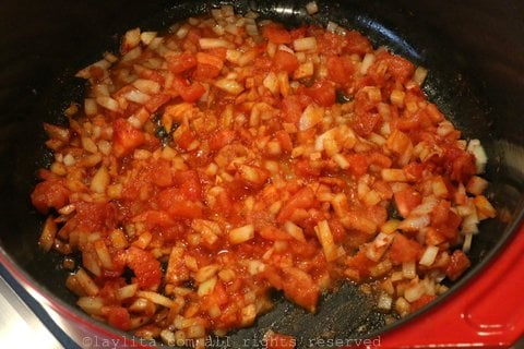 Preparando el refrito para la sopa con cebolla, tomate, ajo, achiote y comino