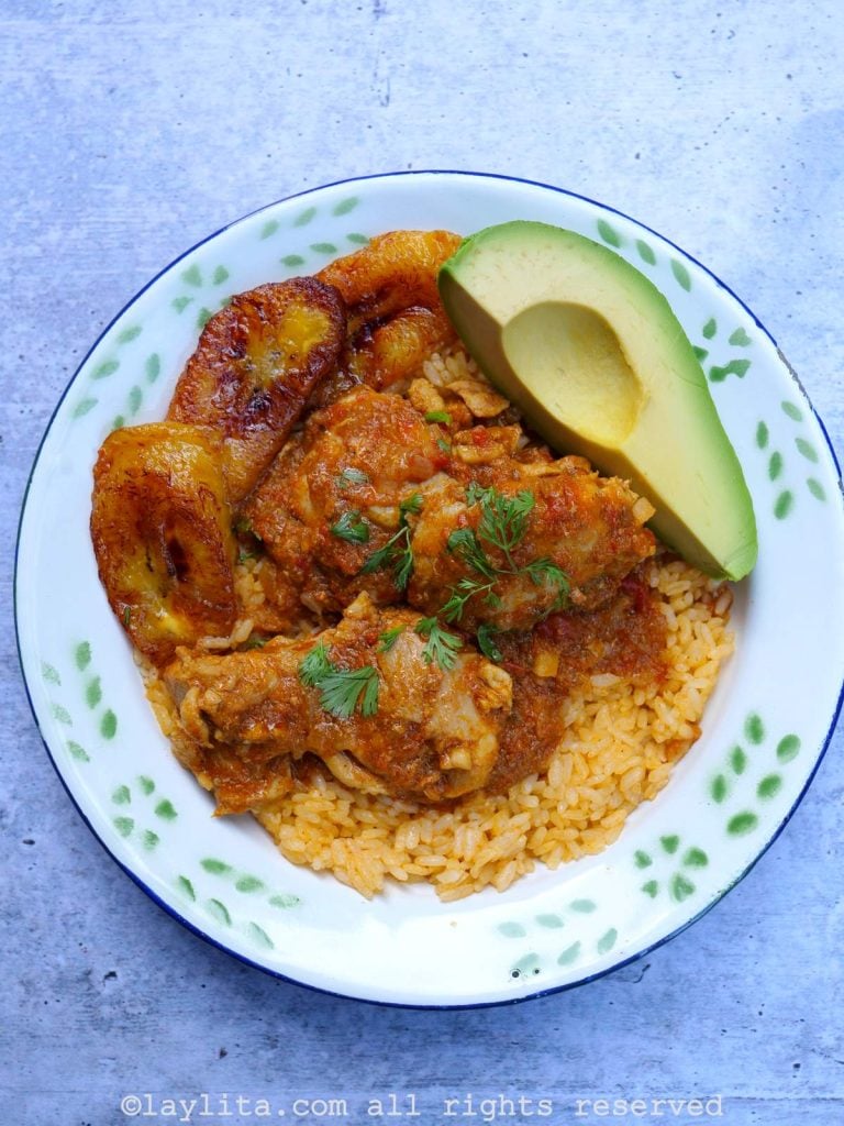 Ecuadorian seco de pollo chicken stew with yellow achiote rice, fried ripe plantains and avocado