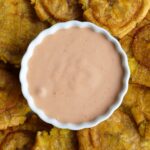 Salsa rosada, salsa rosa, salsa coctel, salsa golf, mayoketchup or pink sauce in a white bowl surrounded by plantain chips