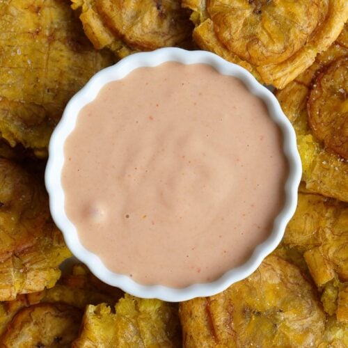 Salsa rosada, salsa rosa, salsa coctel, salsa golf, mayoketchup or pink sauce in a white bowl surrounded by plantain chips