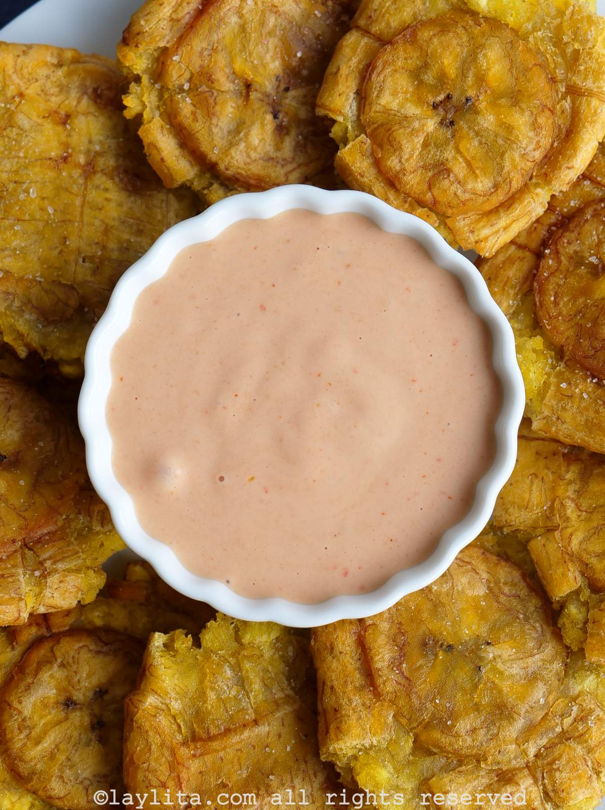 Salsa rosada, salsa rosa, salsa coctel, salsa golf, mayoketchup or pink sauce in a white bowl surrounded by plantain chips