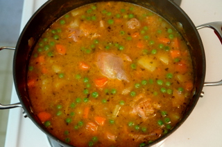 Chicken rice soup with carrots, potatoes and peas