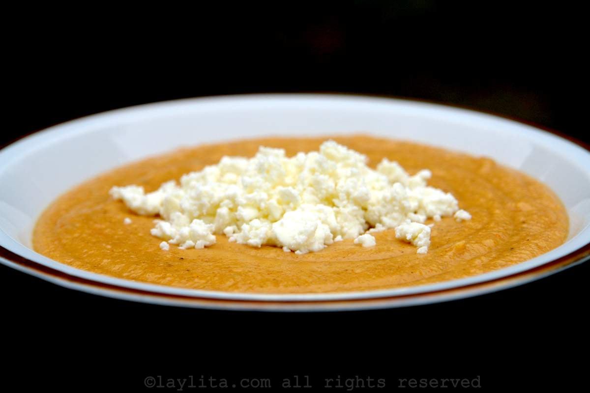 Sweet ripe plantain purée topped with crumbled cheese in a white bowl