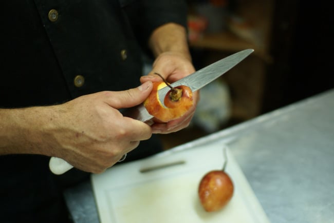 The chef at Tianguez peeling a tree tomato