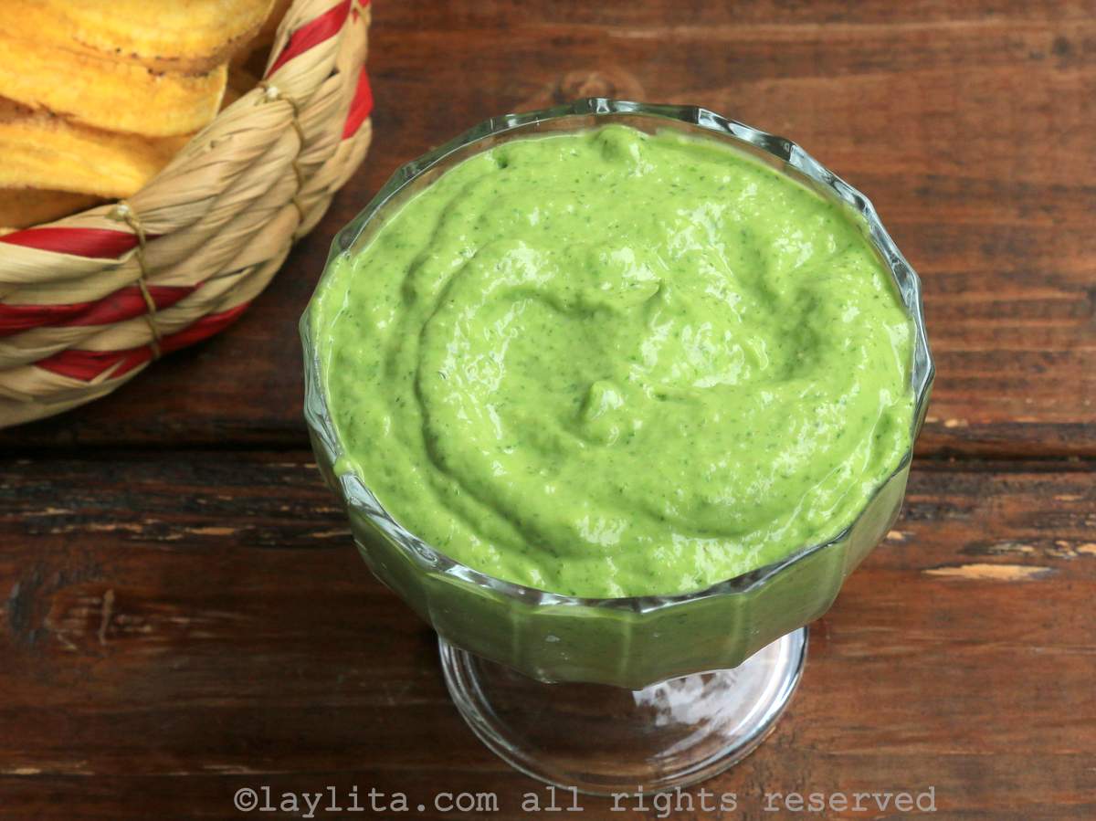 Bowl of avocado salsa with plantain chips in the background