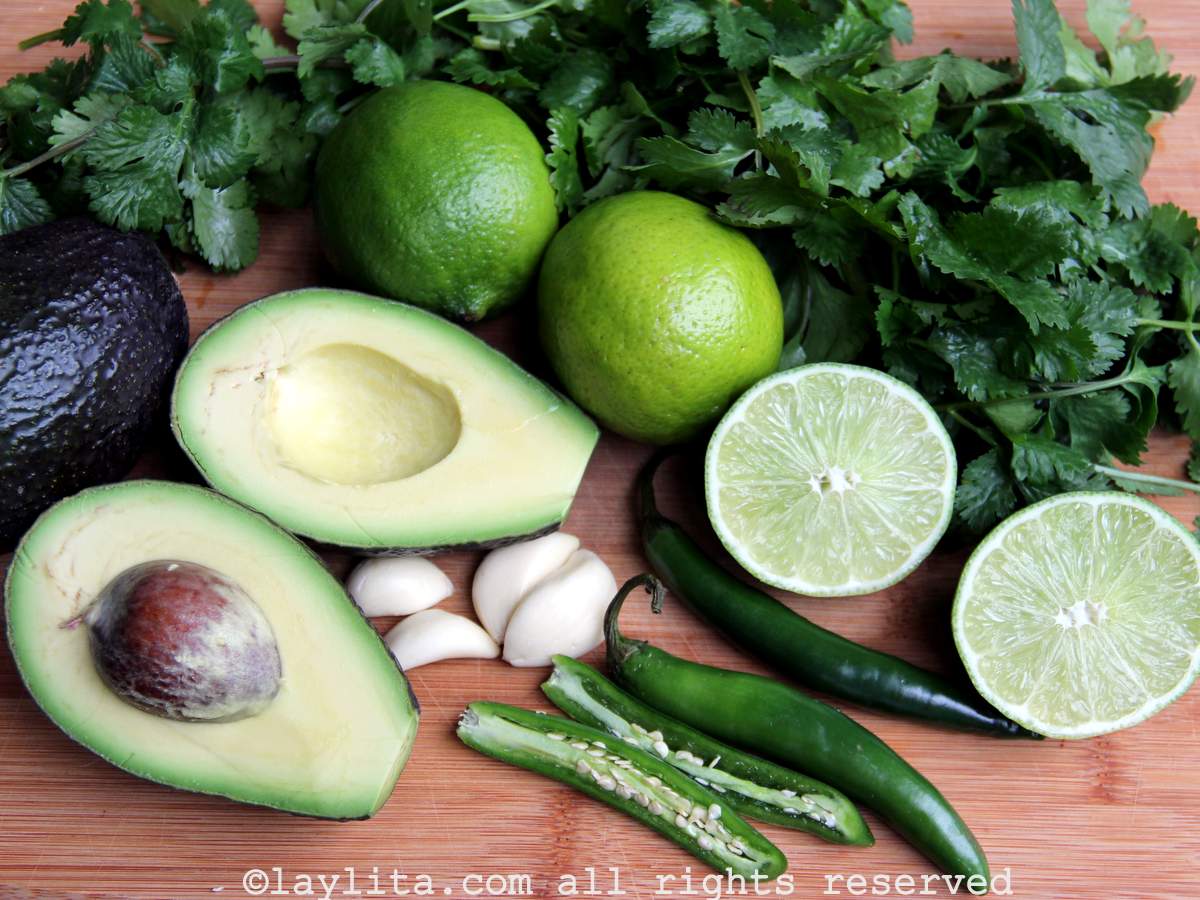 Ingredients for avocado salsa on a wood cutting board