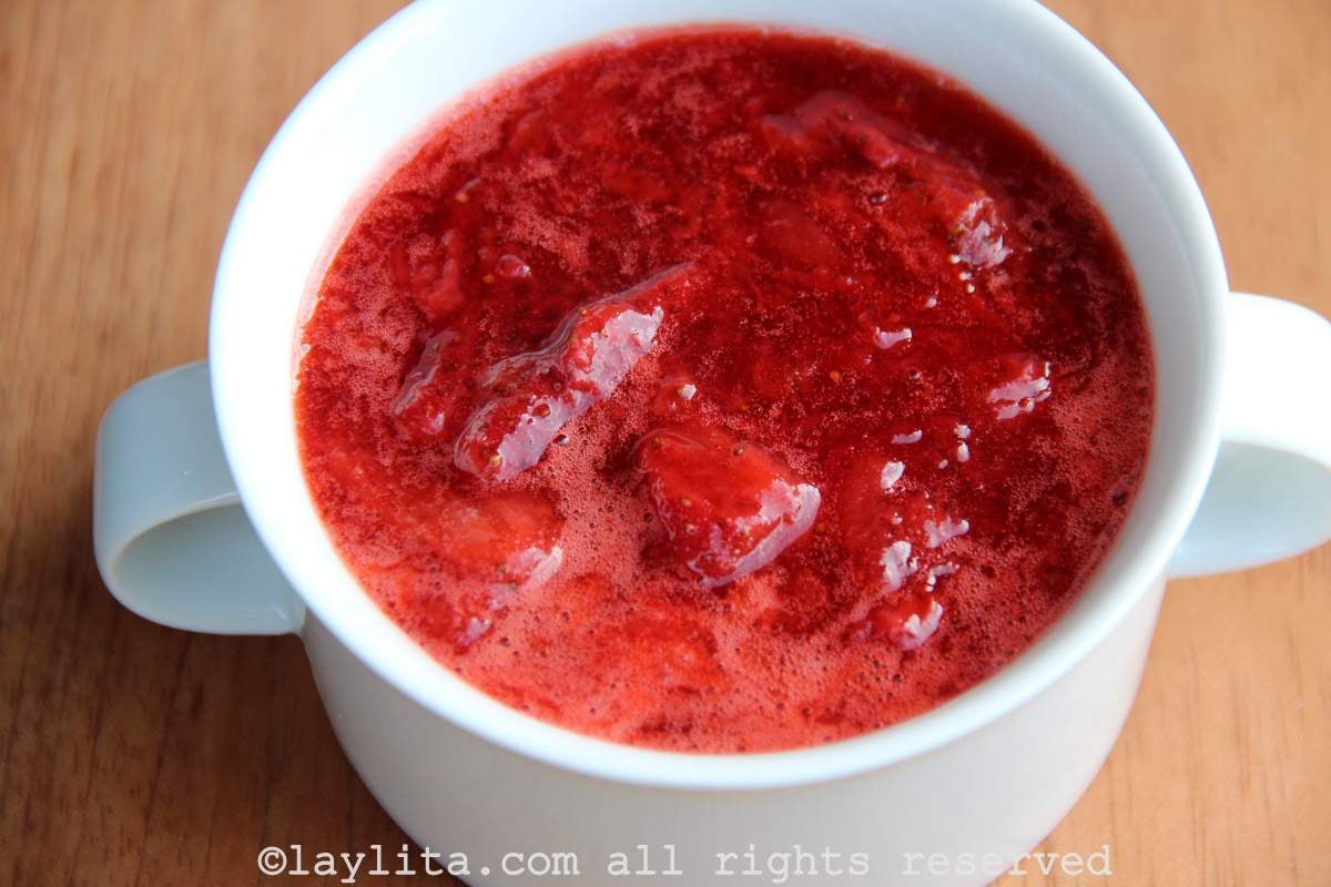 Strawberry sauce A bowl of strawberry sauce in a white bowl on top of wooden table