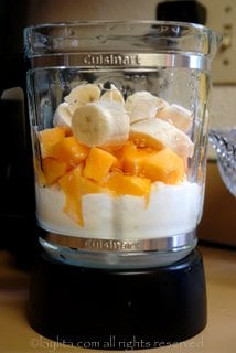 Misture os pedaços de papaia, as fatias de banana, o iogurte, o suco de laranja e o mel no liquidificador
