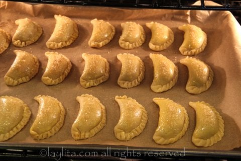 Brush the empanadas with egg wash and sprinkle sugar on top