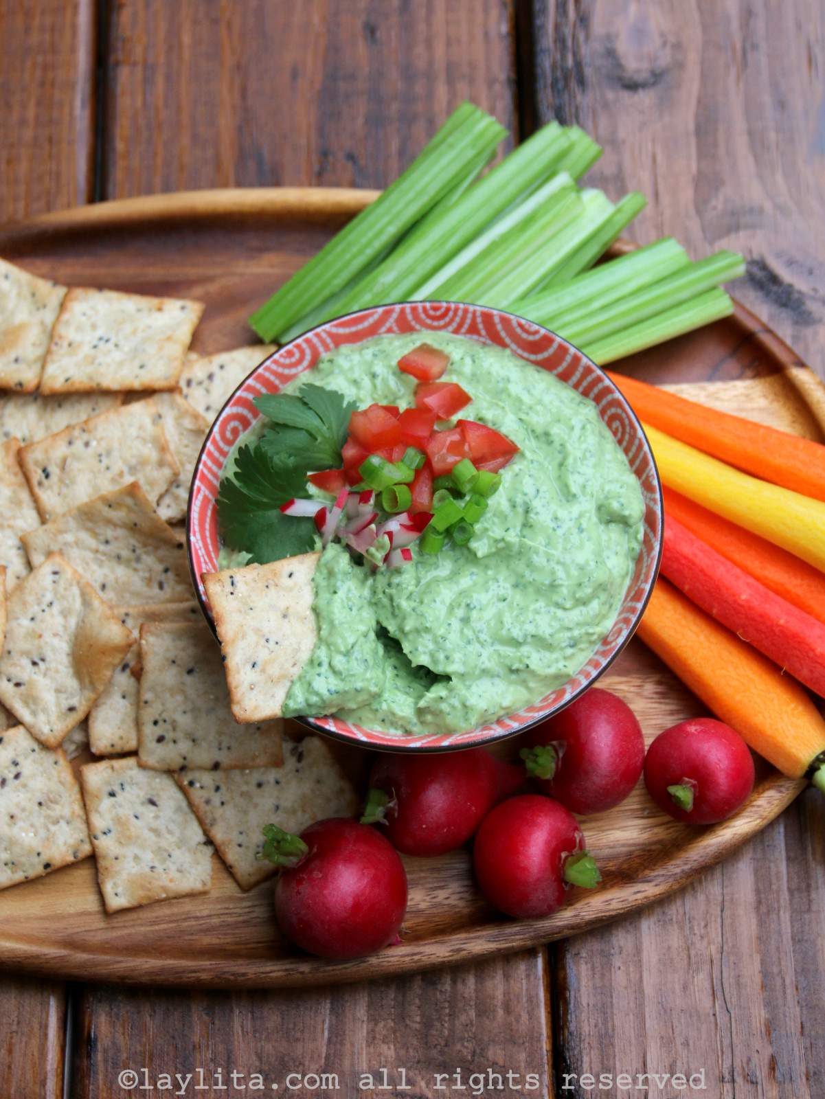 Spicy and tangy avocado yogurt dip recipe - served with carrots, radishes, celery sticks and crackers