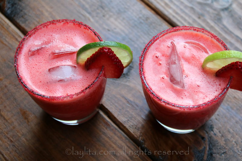 Garnish the strawberry margaritas with lime and strawberry slices