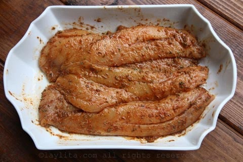 Frote los filetes de pescado con el adobo de naranja agria y déjelos marinar en la refrigeradora 