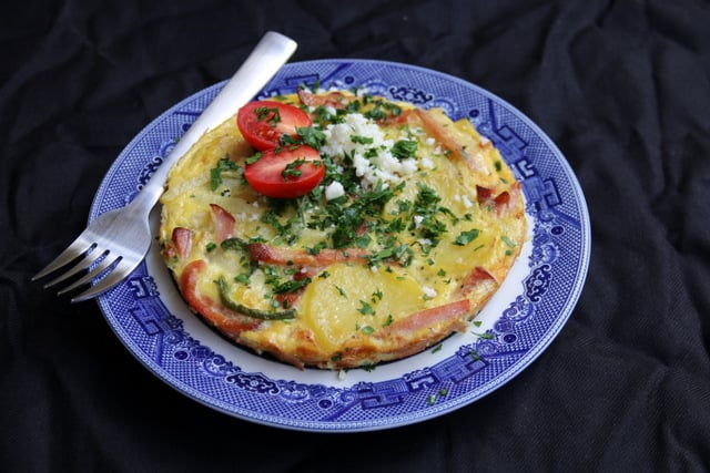 Potato and ham tortilla with chopped parsley and queso fresco