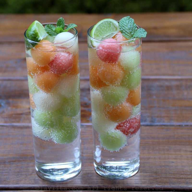 Refreshing sparkling water with melon ball ice cubes, lime and mint