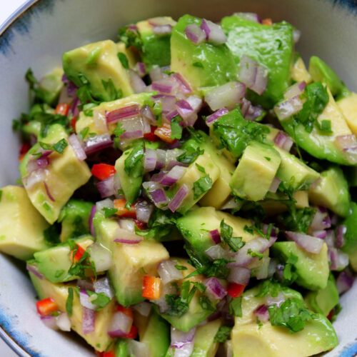 Chopped avocado salsa topping in a white and blue bowl