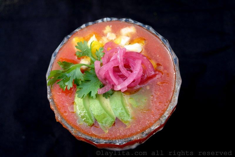 Gazpacho garnished with avocado, egg, and onions