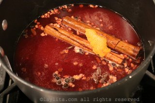 Simmer the spices with water, panela or piloncillo, orange peel, and blood orange juice