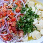 Add tomato and onion curtido salsa to hearts of palm ceviche mix