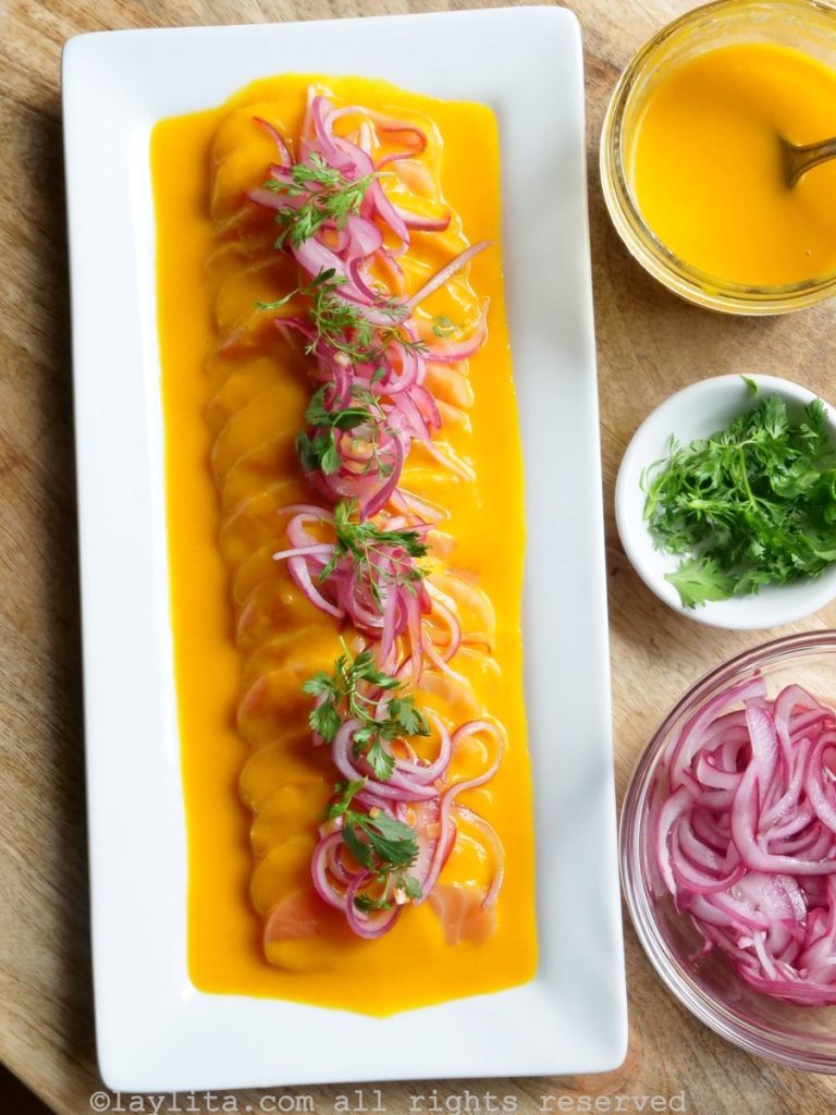 Easy recipe to make Peruvian salmon tiradito with passion fruit aji sauce. This mouthwatering dish features sashimi style salmon topped with a spicy passion fruit aji amarilllo sauce, pickled red onions and chopped cilantro.