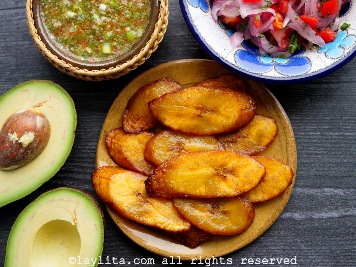 Fried ripe plantains, tomato onion curtido, aji sauce and avocado are popular Ecuadorian side dishes