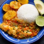 Sudado de pescado (stewed fish) served on a blue plate with rice