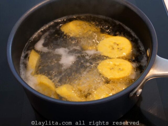 Preparing boiled green plantains for fish stew.