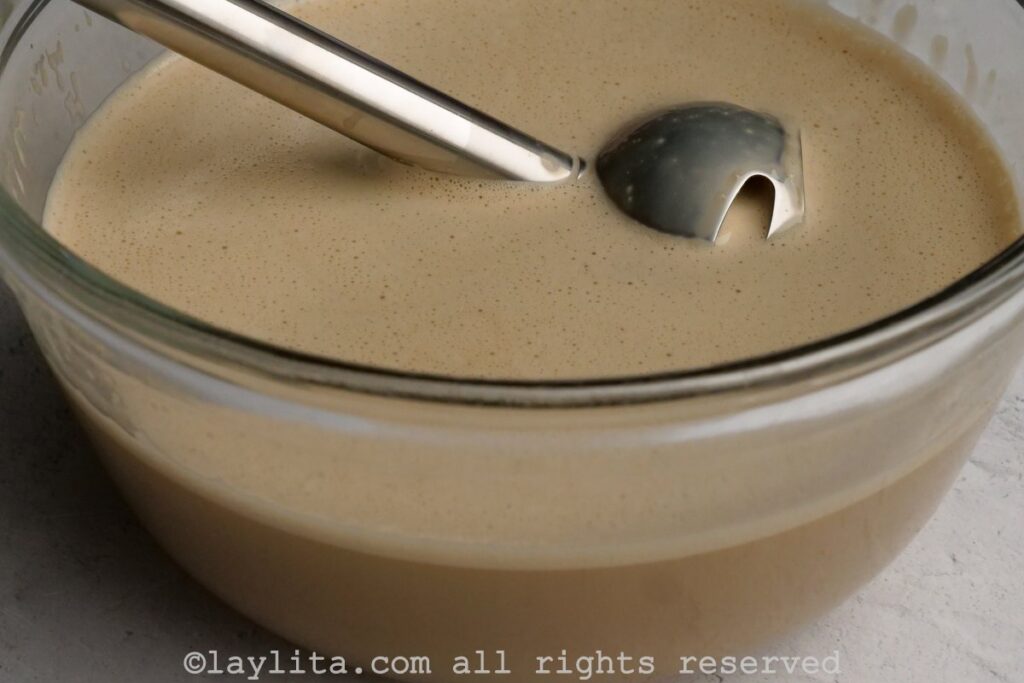 Ingredients for coffee flan in a mixing bowl with an immersion blender