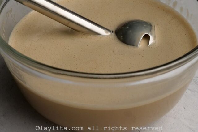Ingredients for coffee flan in a mixing bowl with an immersion blender