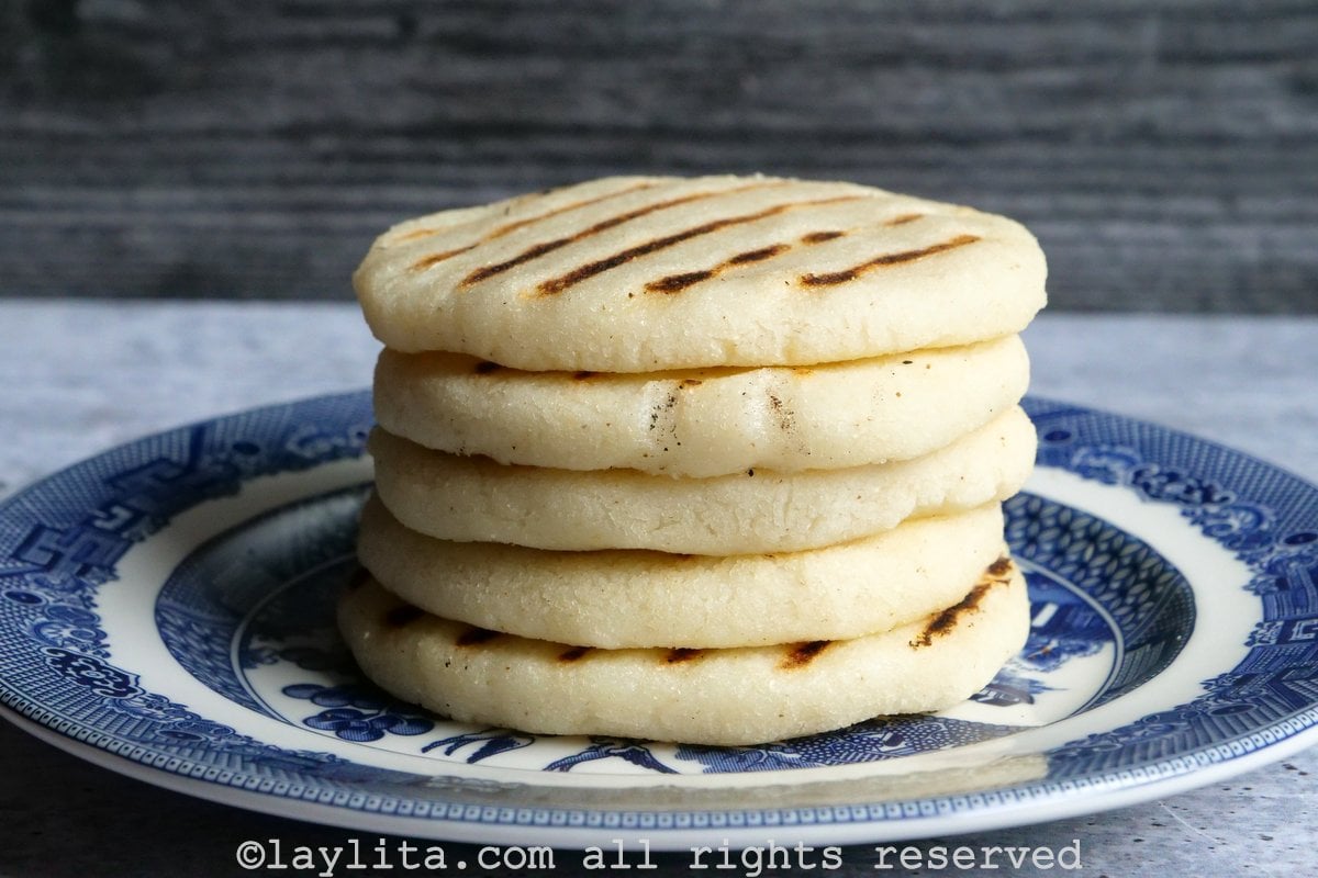 Stack of arepas on a blue and white plate.