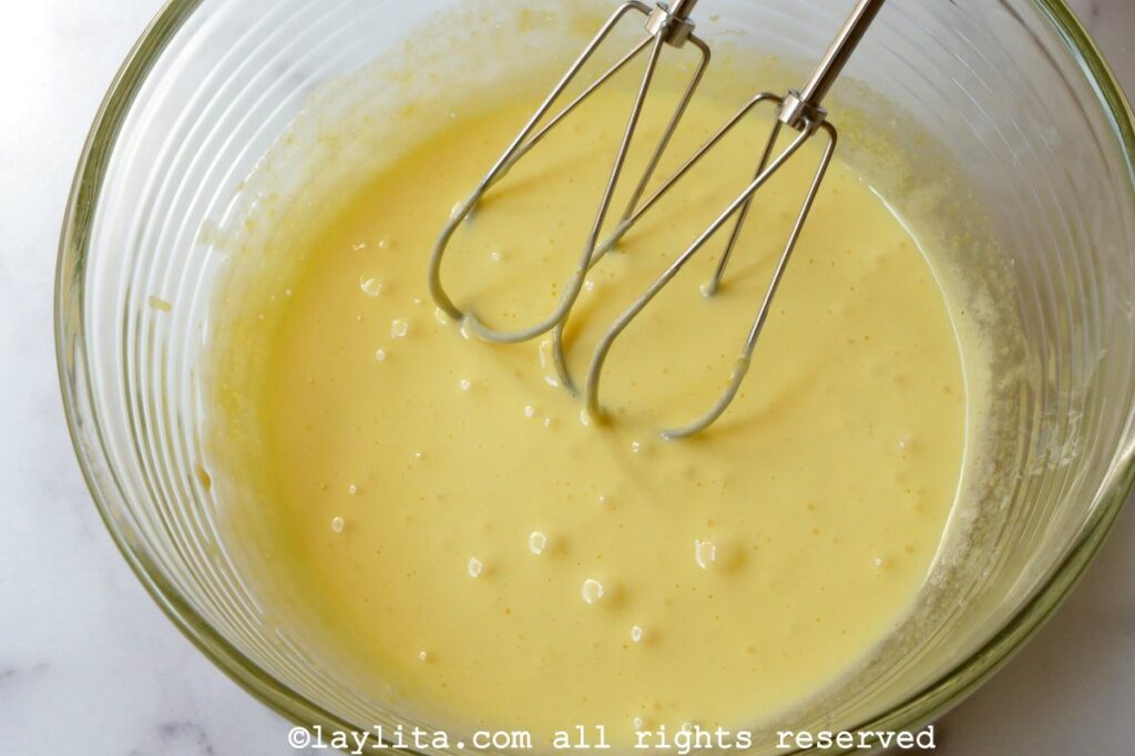 Cream mixture mixed with the egg mixture in a glass mixing bowl.
