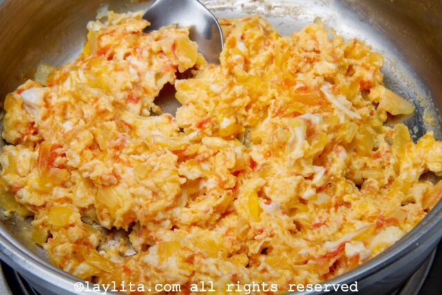 Making huevos pericos style scrambled eggs in a skillet