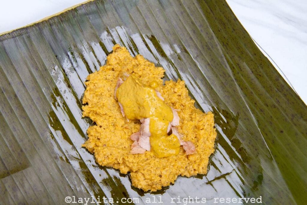 Plantain leaf with plantain dough, fish, and peanut sauce on top