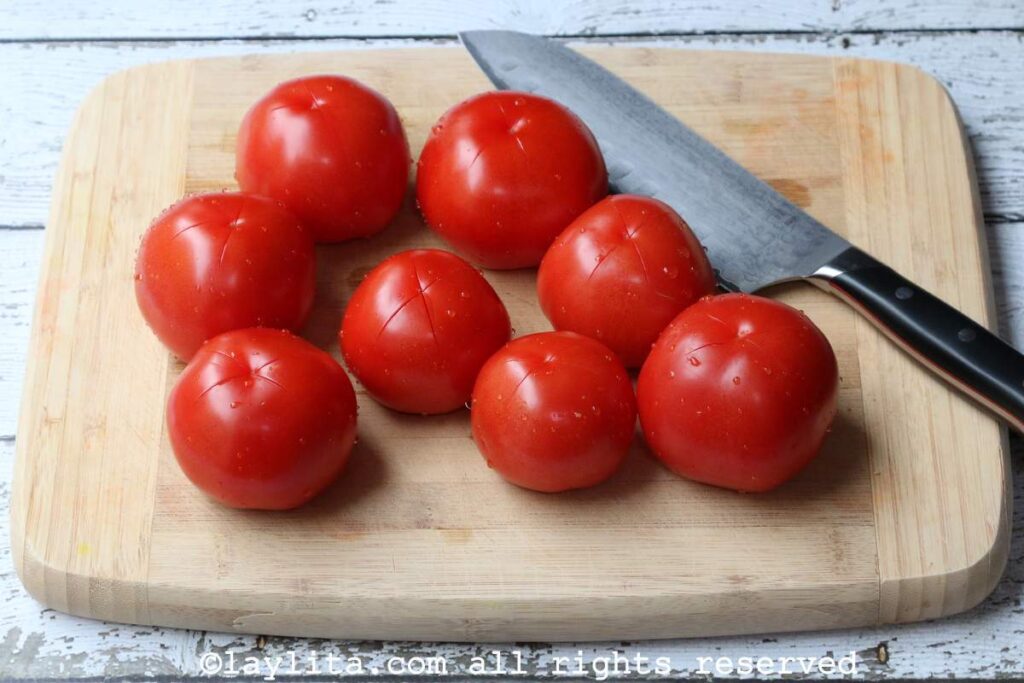 Tomatoes on cutting board with a knife