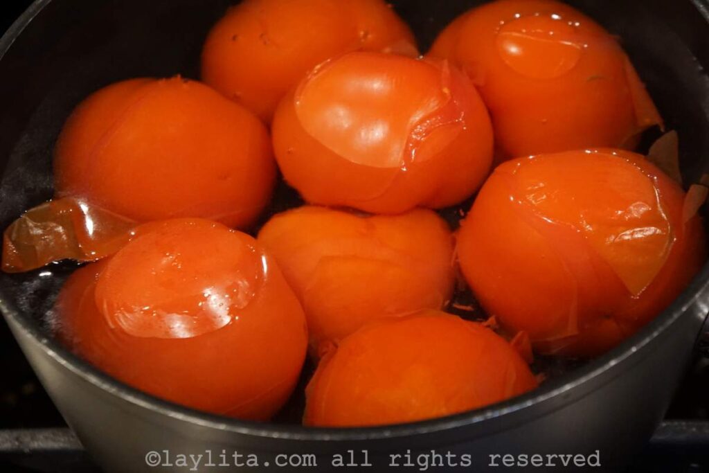 Fresh tomatoes in a pot of boiling water.