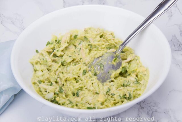 Venezuelan style avocado chicken salad mixture in a white mixing bowl.